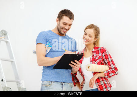 smiling couple with clipboard and wallpaper roll Stock Photo