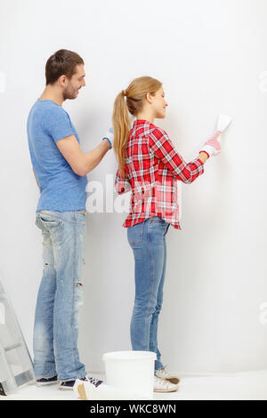 repair, renovation and home concept - smiling couple doing renovations at home Stock Photo