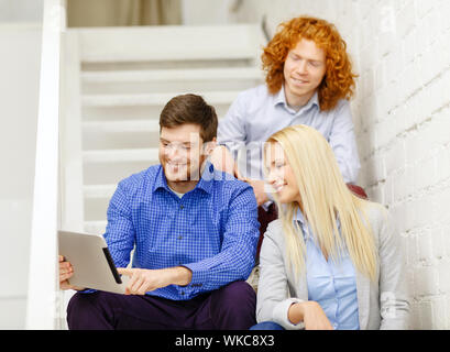 team with tablet pc computer sitting on staircase Stock Photo