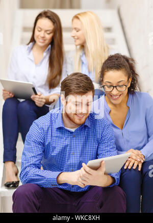 team with tablet pc computer sitting on staircase Stock Photo