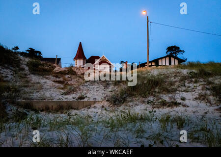 Uruguay: Uruguay, La Floresta, small city and resort on the Costa de Oro (Golden Coast). At dusk, a switched on street lamp and some houses on dunes Stock Photo