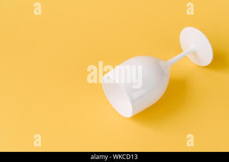 Creative festive white glass on a yellow background.  Stock Photo