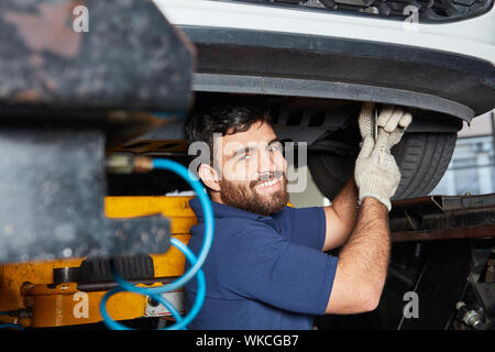 Young man as a mechatronics apprentice at the auto repair shop in the car workshop Stock Photo