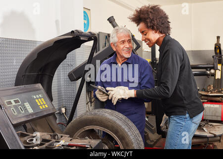 Car champion and woman in training to mechatronics engineer work with tablet computer Stock Photo