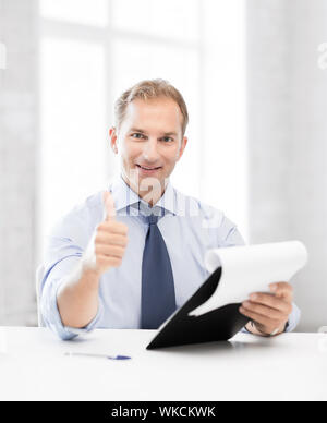 handsome businessman with papers showing thumbs up Stock Photo