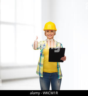 smiling woman in helmet with clipboard Stock Photo