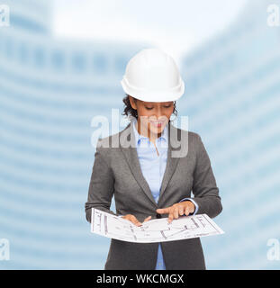 businesswoman in white helmet with blueprint Stock Photo