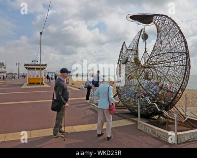 Visitors looking at a Sculpture highlighting plastic waste on Southsea promenade, Hampshire, England. Stock Photo
