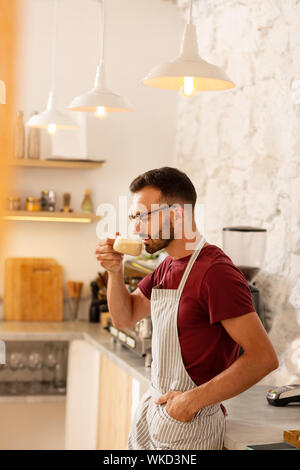 Man drinking coffee. Bearded successful businessman owning coffee room standing and drinking coffee Stock Photo