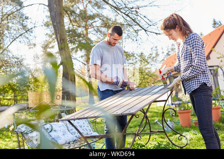 Couple painting furniture and renovating in the garden Stock Photo