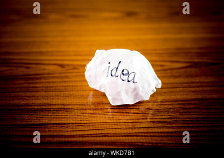 writing idea word on crumpled on wood background Stock Photo