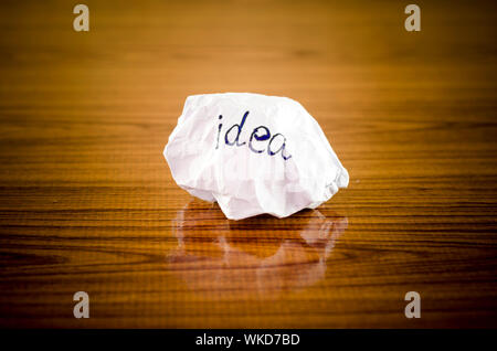 writing idea word on crumpled on wood background Stock Photo