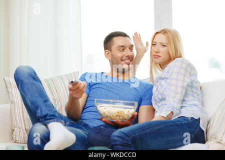 smiling couple with popcorn choosing what to watch Stock Photo