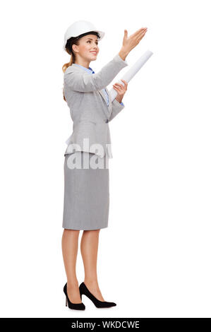 building, developing, consrtuction and architecture concept - friendly young smiling architect in white helmet with blueprint Stock Photo