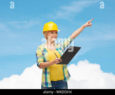 smiling woman in helmet with clipboard Stock Photo