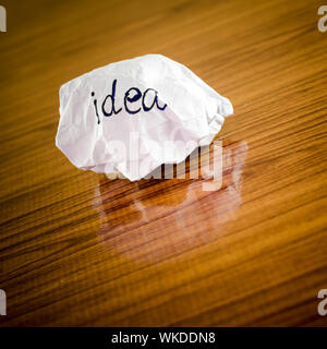 writing idea word on crumpled on wood background Stock Photo