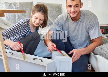 Handyman couple painting and renovating drawers in the new apartment Stock Photo