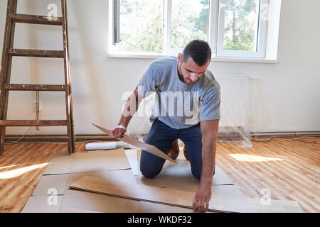 Construction Worker Laying Hardwood Flooring In House Stock Photo
