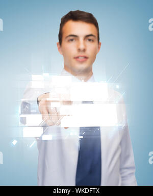 business and office, people concept - friendly young buisnessman pointing finger to virtual screen Stock Photo