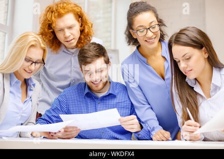 business, office and startup concep - smiling creative team with papers working in office Stock Photo