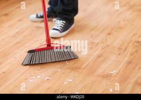close up of male brooming wooden floor Stock Photo