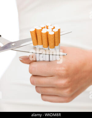 cutting down on cigarettes Cutting cigarettes by scissors. Anti smoking or quit smoking concept Stock  Photo