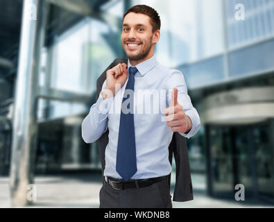 business and office concept - handsome buisnessman with jacket over shoulder showing thumbs up Stock Photo