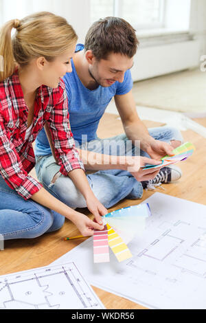 smiling couple looking at color samples at home Stock Photo