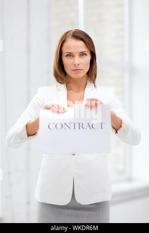 concentrated businesswoman tearing contract Stock Photo