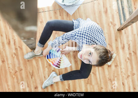 Young woman with color fan is looking for the right wall color for painting in new home Stock Photo