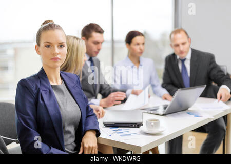 businesswoman in office with team on the back Stock Photo