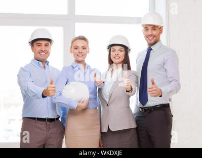 business, architecture and office concept - happy team of architects in office showing thumbs up Stock Photo