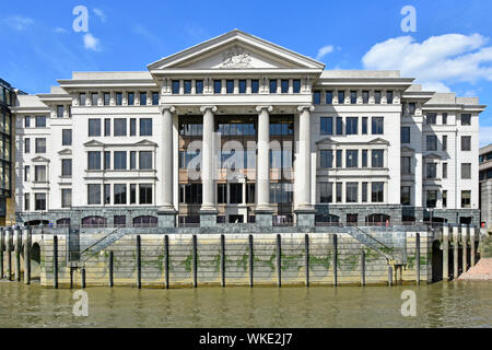Classical granite &  limestone riverside facade of 1980s Vintners Place office building at low tide shows emergency grab chains River Thames London UK Stock Photo