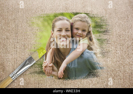 Composite image of mother and daughter in the park against weathered surface with paintbrushes Stock Photo