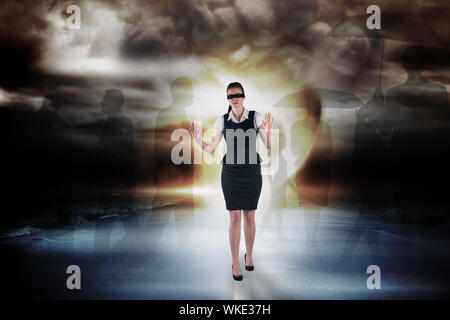 Redhead businesswoman in a blindfold against stormy sky with tornado over road Stock Photo