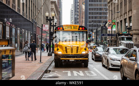 Chicago, Illinois, US. May 9, 2019: Back to school. School bus yellow color on the road, city center, spring morning Stock Photo