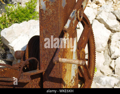 A rusty gear wheel in old, corroded mechanism of boat winch. Stock Photo