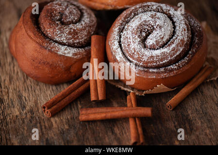 Fresh cinnamon buns on wooden background. Sweet cinnamon rolls. Stock Photo