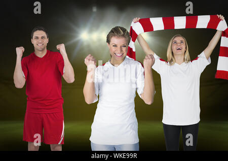 Composite image of various football fans against football pitch under spotlights Stock Photo