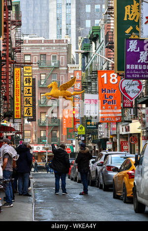 NEW YORK CITY /  USA - JANUARY 21, 2018: Pell Street overloaded by advertising signs written in Chinese, Chinatown neighborhood, Manhattant, NYC. Stock Photo