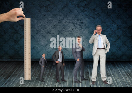 Composite image of hand measuring stages of businessmans life with ruler against dark grimy room Stock Photo