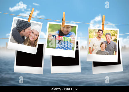 Composite image of instant photos hanging on a line against ocean and cityscape Stock Photo