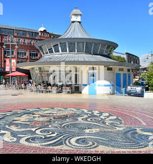 Pebble mosaic in pavement with Debenhams store & people sitting outdoors at Obscura street cafe town centre The Square Bournemouth Dorset England UK Stock Photo