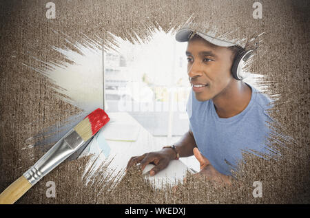 Composite image of cool designer at work with paintbrush dipped in red against weathered surface Stock Photo