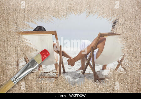 Composite image of couple on the beach in deck chairs with paintbrush dipped in red against weathered surface Stock Photo