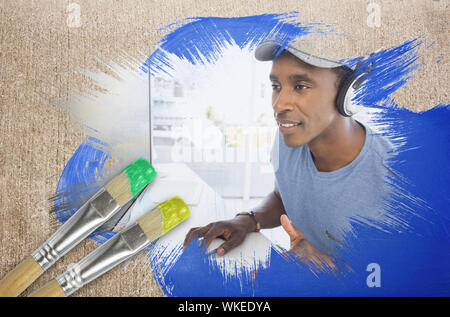Composite image of cool designer at work with paintbrush dipped in yellow against weathered surface Stock Photo
