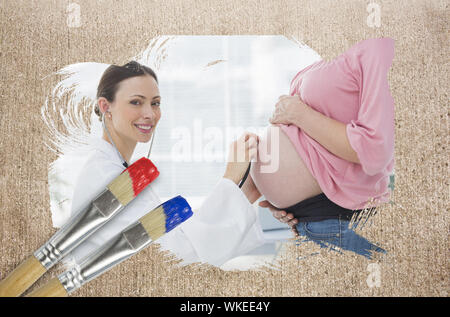 Composite image of pregnant woman at check up with doctor with paintbrush dipped in blue against weathered surface Stock Photo