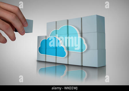 Hand building wall showing two blue clouds for cloud computing Stock Photo