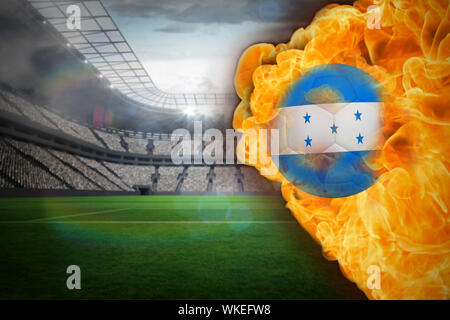 Composite image of fire surrounding honduras flag football against large football stadium with lights Stock Photo