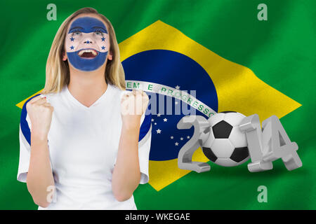 Excited honduras fan in face paint cheering against world cup 2014 with brasil flag Stock Photo